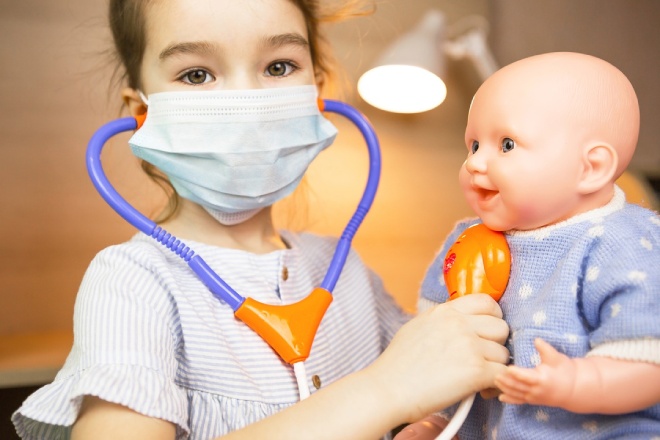 New Pediatric Care 1 A girl with a doll plays doctor