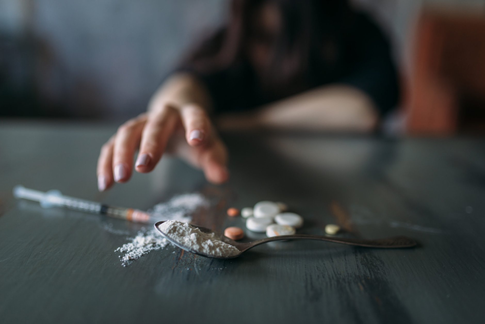 Female junkie hand hand reaching for the dose